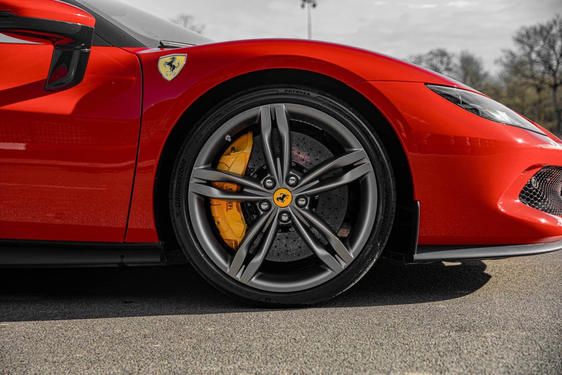 A red Ferrari 296 GTB sports car on a road.
